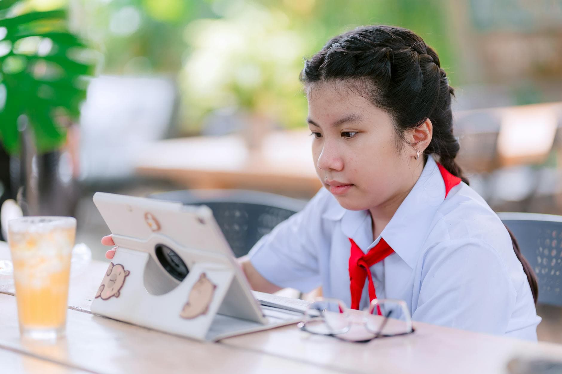 Student using a laptop with AI tools to manage studies and earn online, surrounded by books and a coffee cup, illustrating modern learning and earning